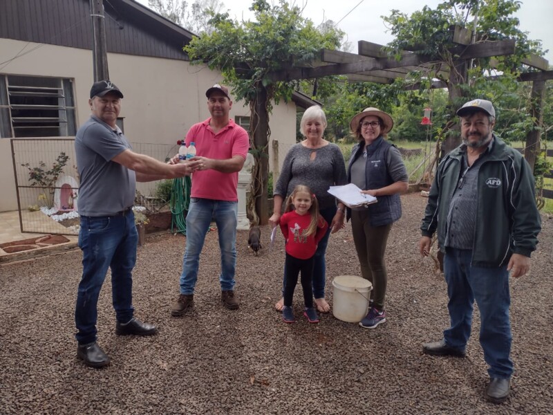 Agricultora Helena Schons e família recebendo o larvicida para aplicação