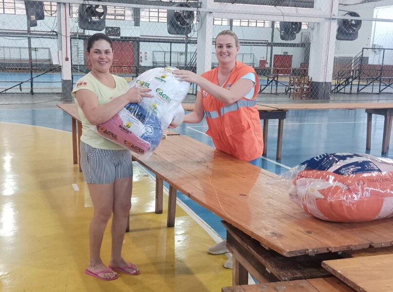 Coordenadora da Defesa Civil do município realizando a entrega dos kits.